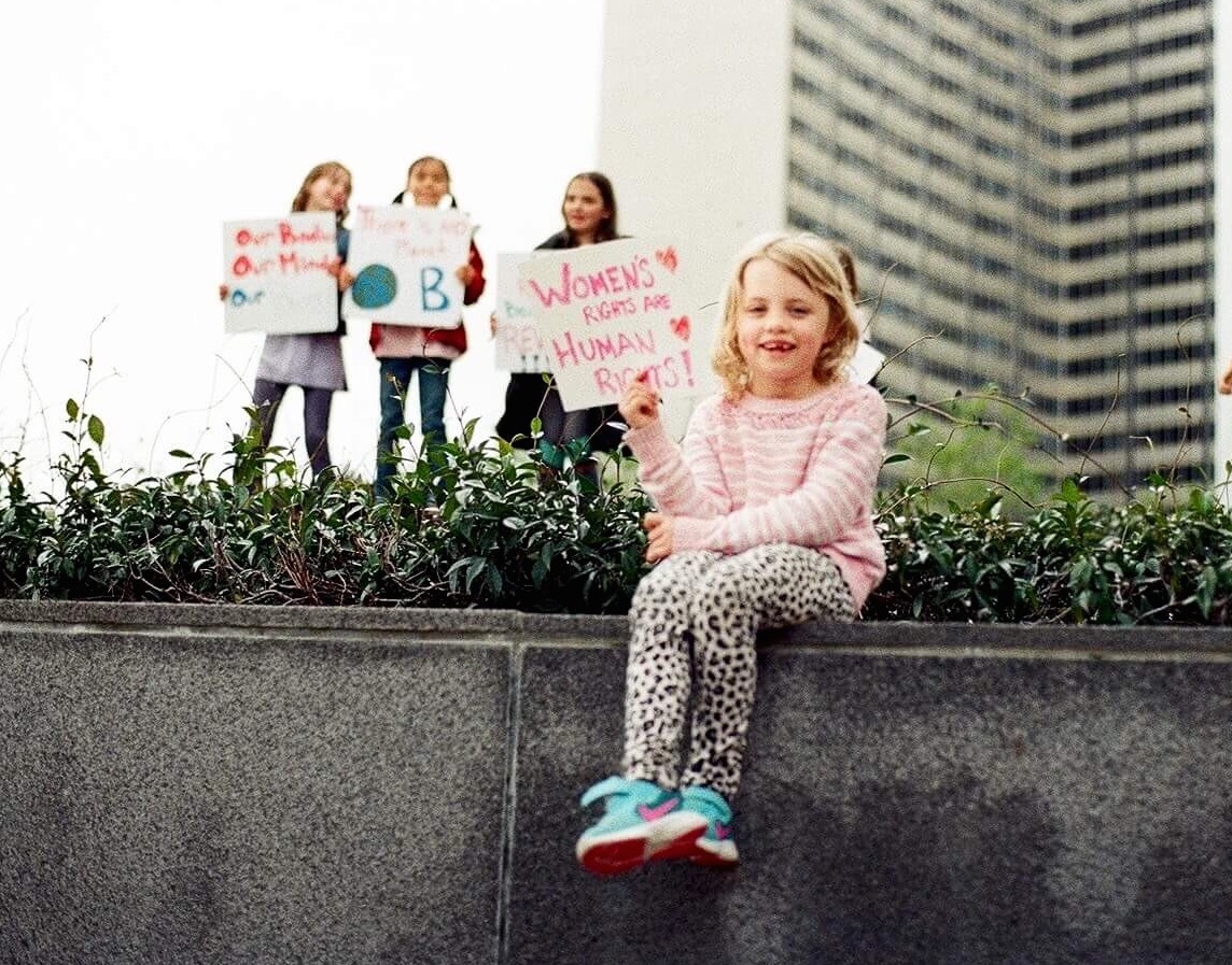 Children holding signs, advocating for climate action outdoors.